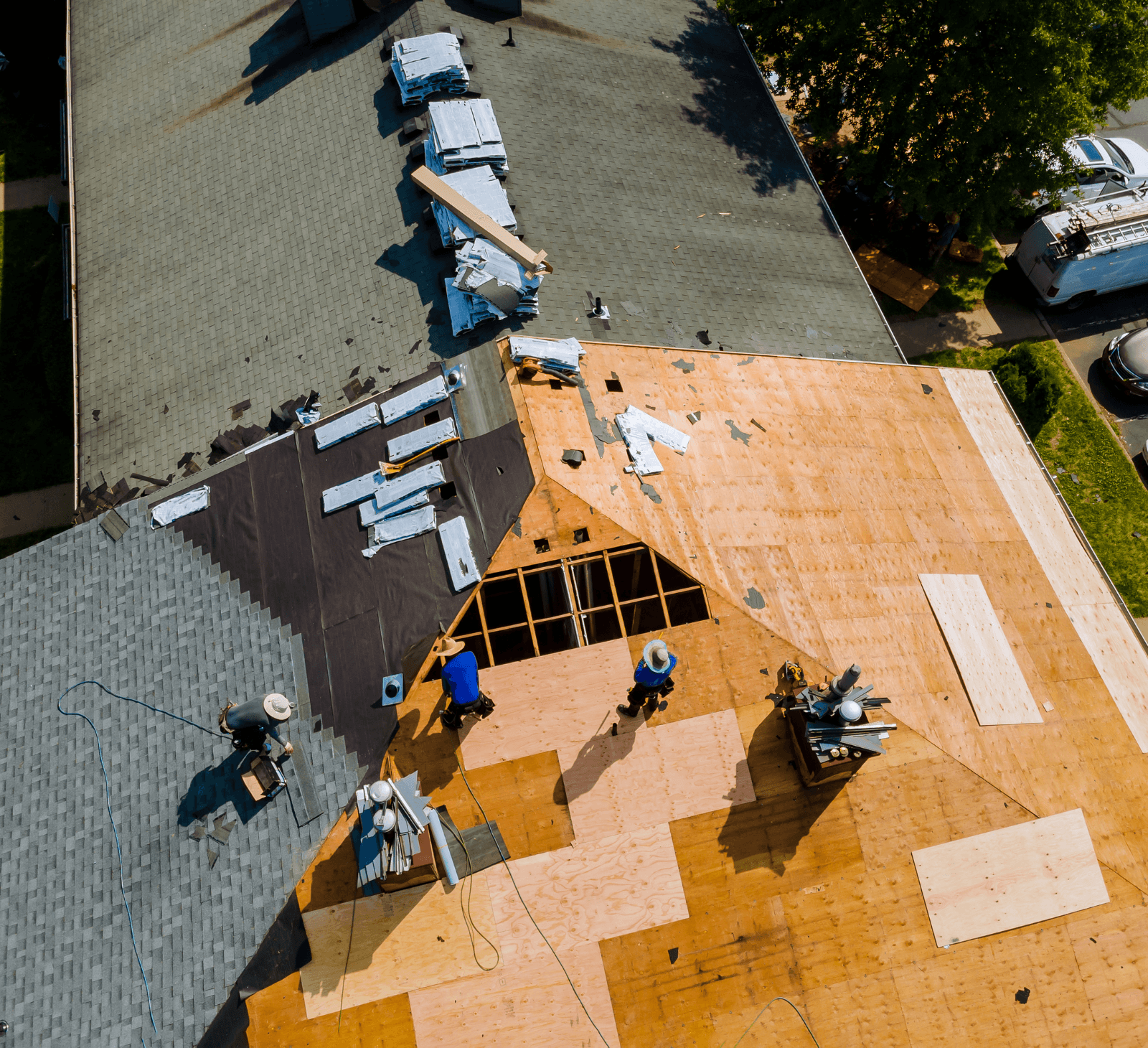 Roofing crew nailing down architectural shingles on a re-roof